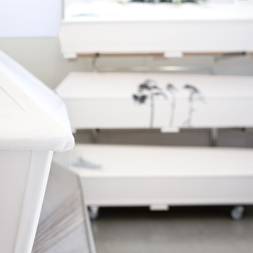 Valkoiset lilja hautakiven paalla.