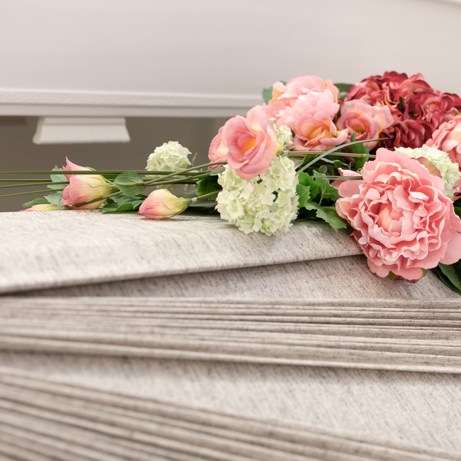 Kynttilan valo loistaa hautalyhdyssa hautakiven vieressa.